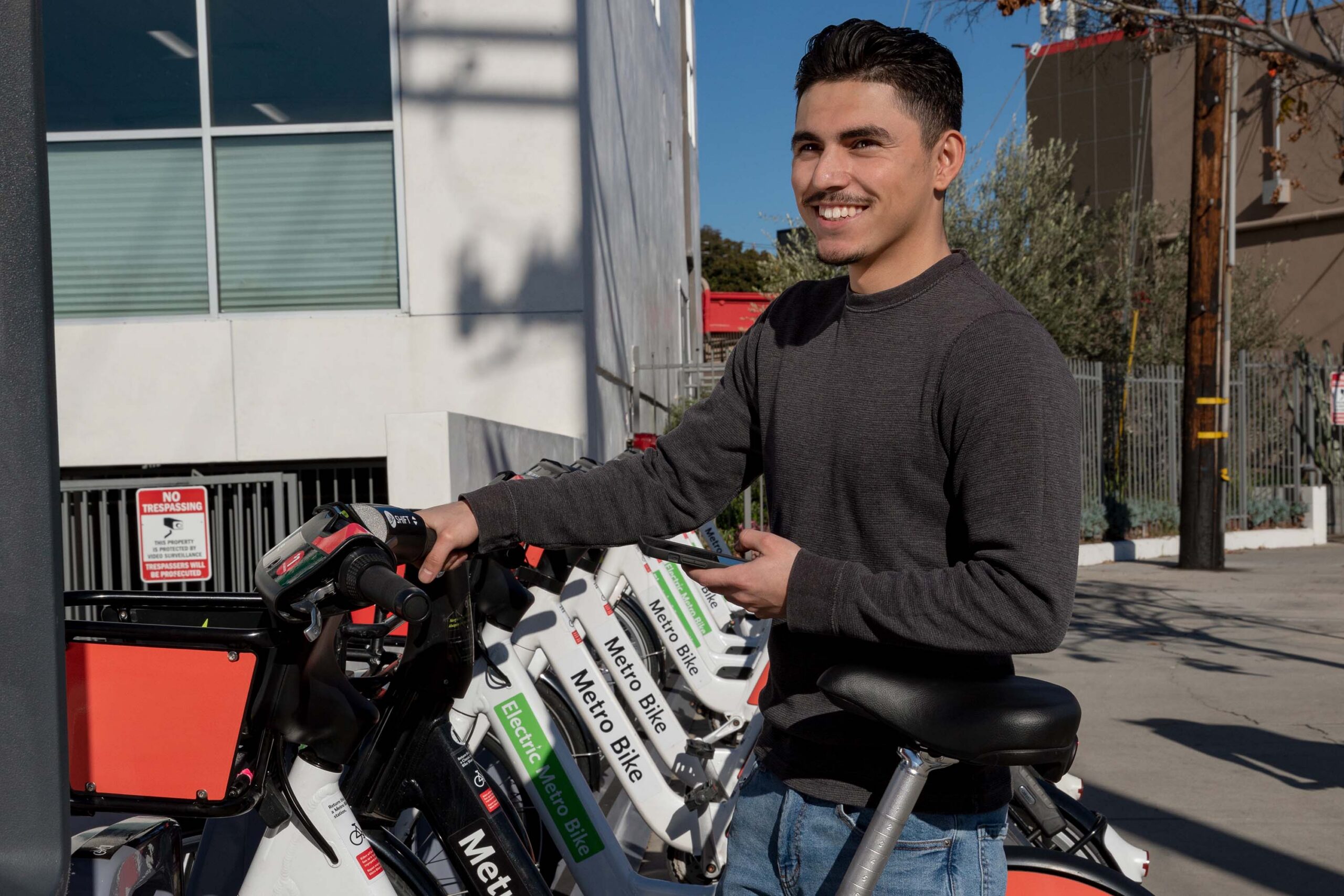 A smiling man stood beside an Electric Metro Bike