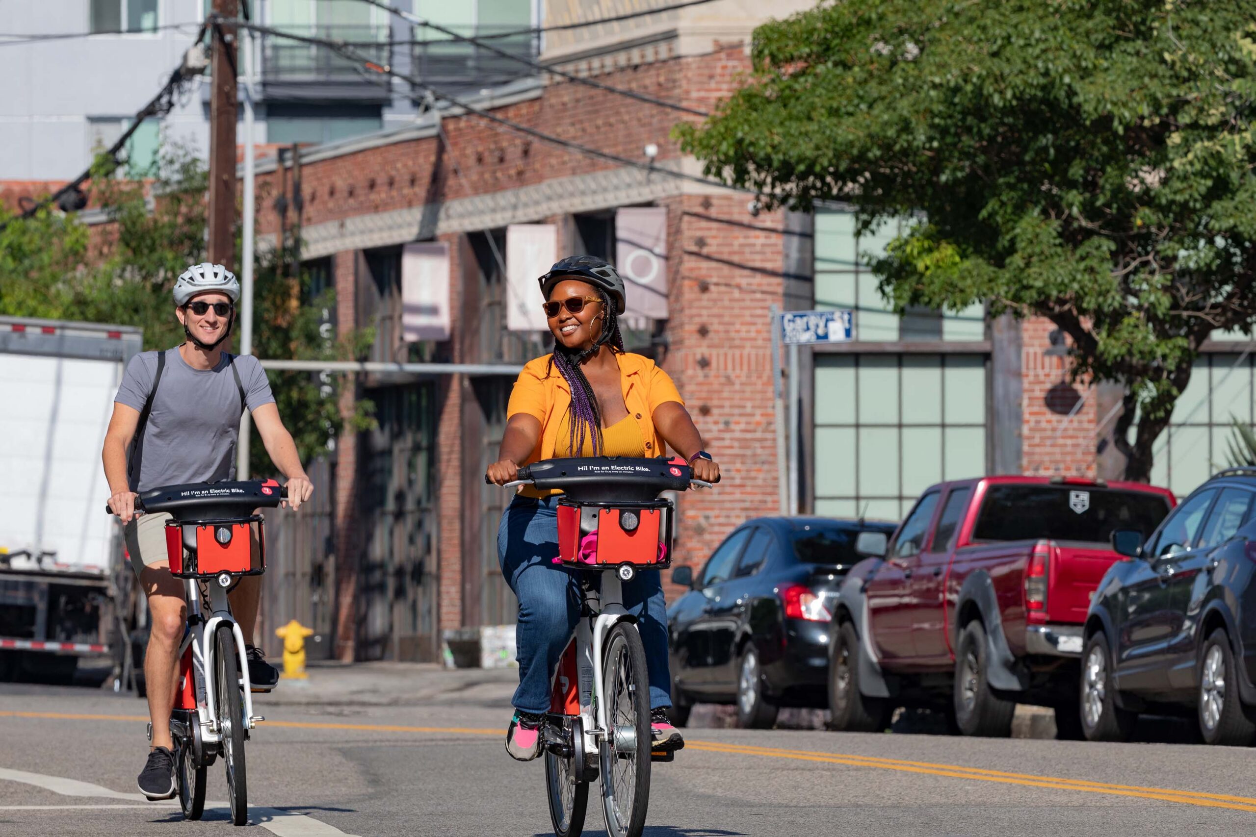 A man and woman riding Metro Bikes side by side
